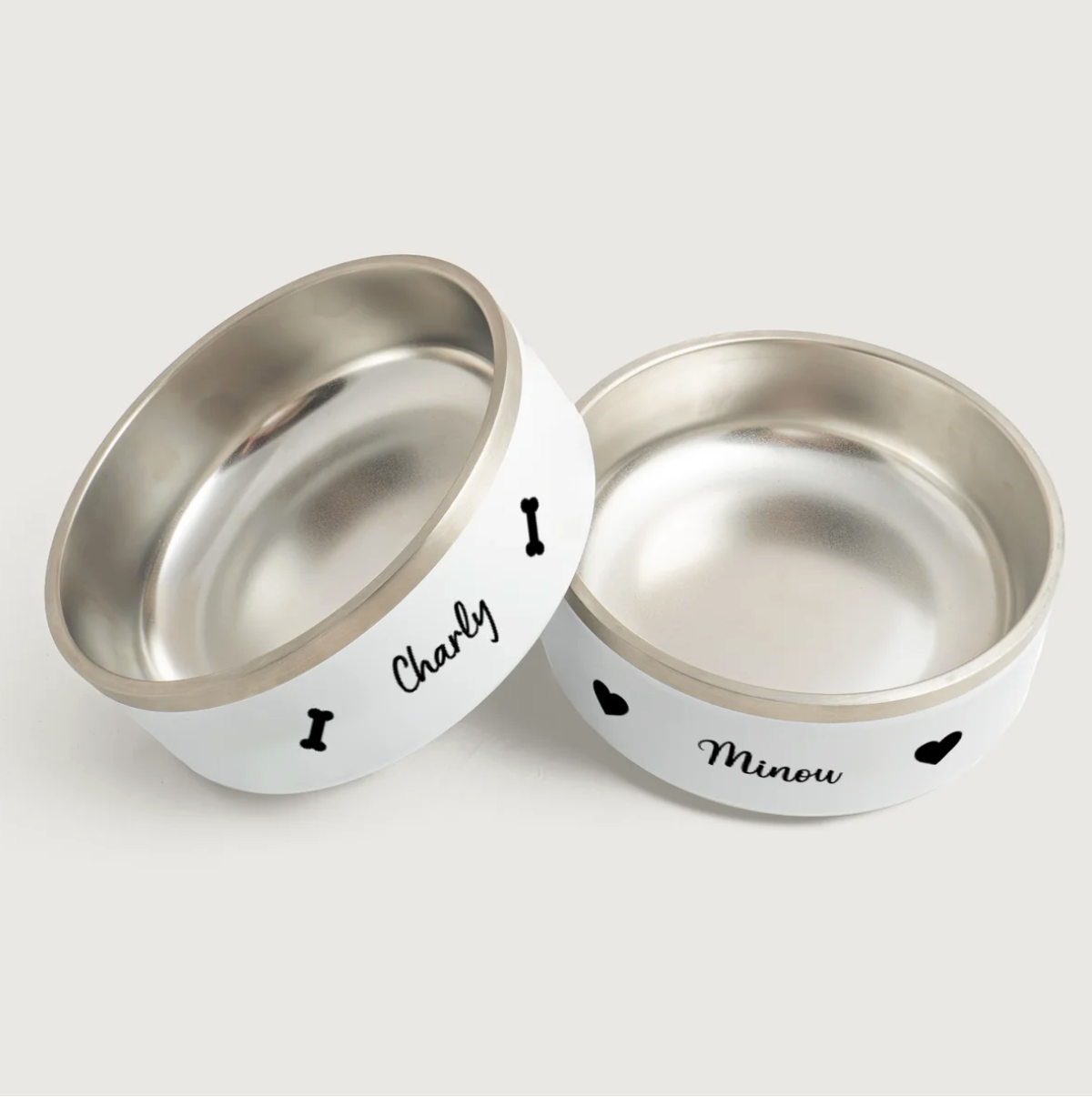 Comederos personalizados de acero inoxidable con exterior blanco, impresos con los nombres Charly y Minou.