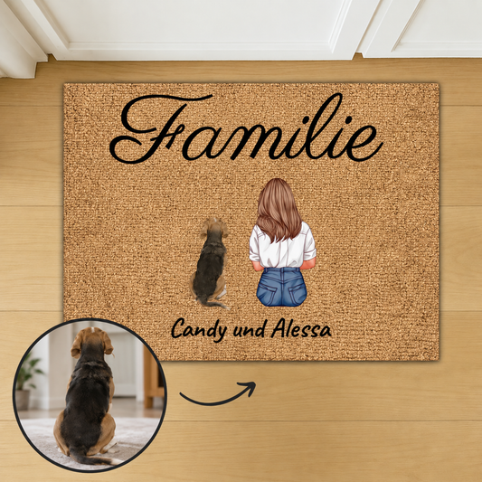 Felpudo de fibra de coco personalizado con la palabra "Familie" e ilustraciones de una mujer y un perro.