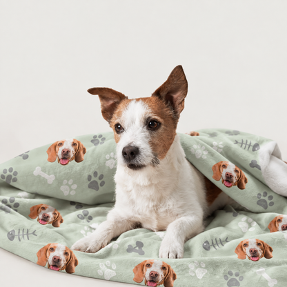 Manta para mascotas personalizada con fondo verde y motivos de perros impresos, envolviendo a un perro.
