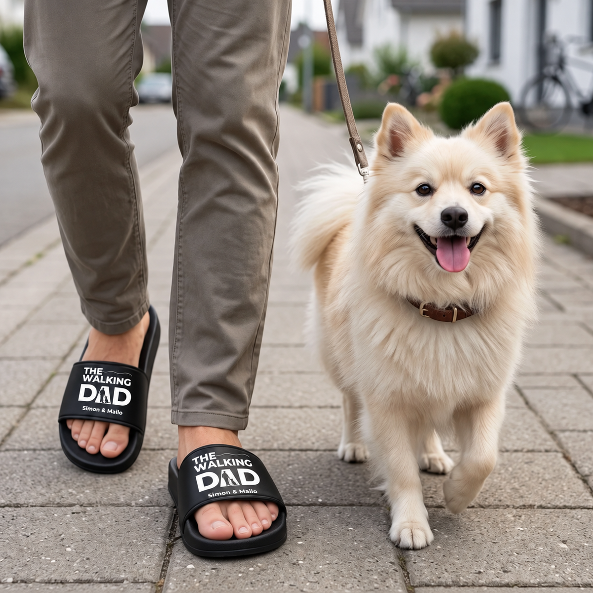 Persona con chanclas negras personalizadas con el estampado "THE WALKING DAD" paseando a un perro.
