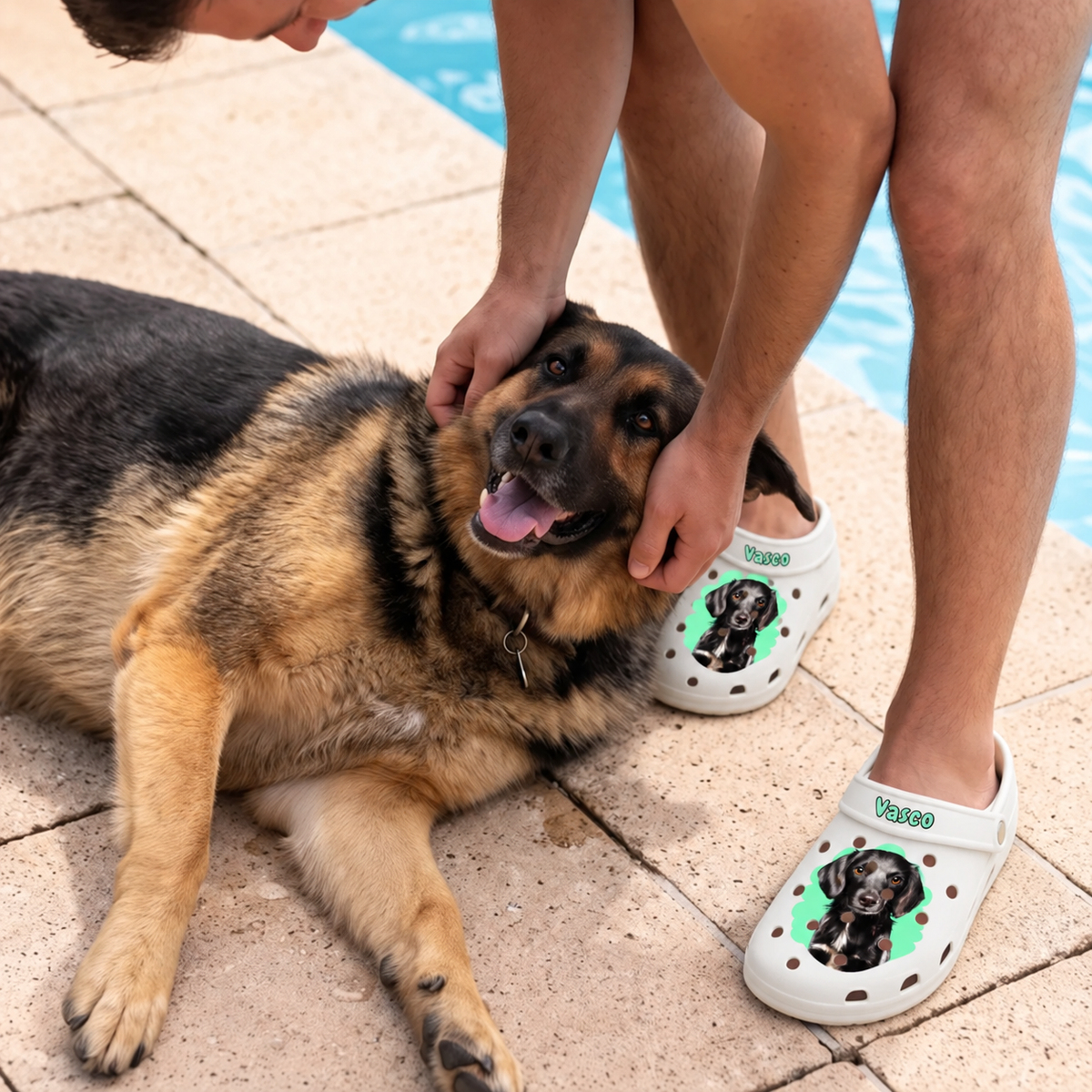 Persona con zuecos blancos personalizados con retrato de mascota, sentada junto a un perro al lado del agua.